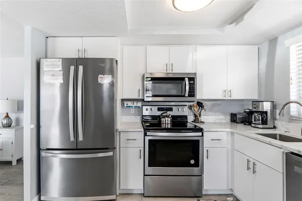 a kitchen with cabinets stainless steel appliances and a window