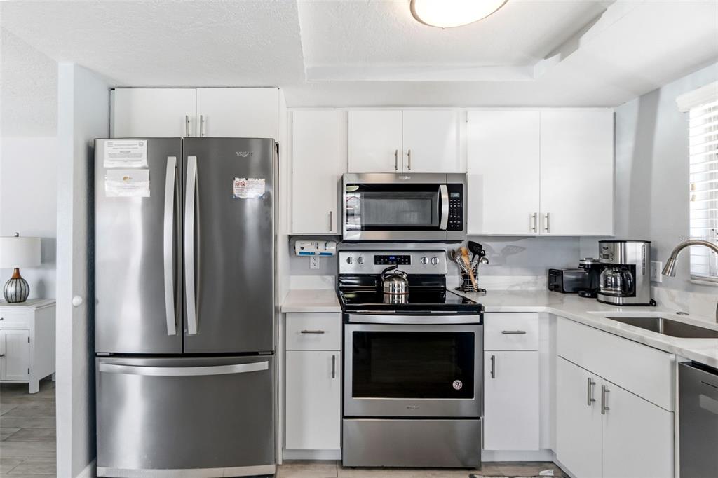 6154 Midnight Pass Road, Unit A05 Sarasota, FL 34242 - Photo 3 of 39 a kitchen with cabinets stainless steel appliances and a window