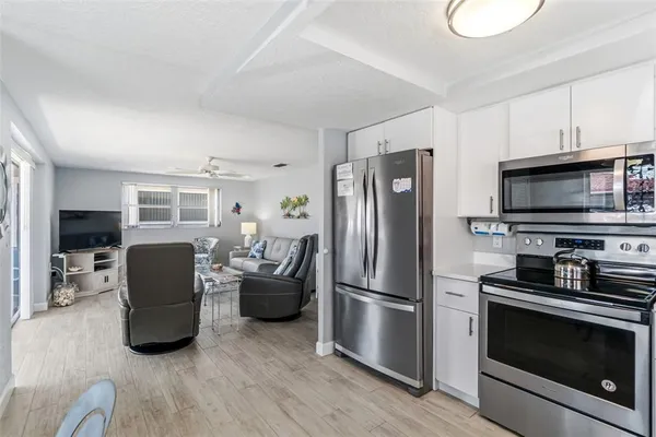 a kitchen with stainless steel appliances granite countertop a refrigerator stove and microwave