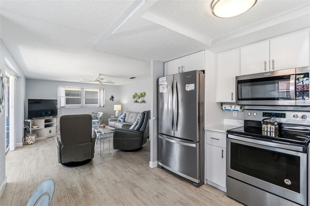 6154 Midnight Pass Road, Unit A05 Sarasota, FL 34242 - Photo 6 of 39 a kitchen with stainless steel appliances granite countertop a refrigerator stove and microwave