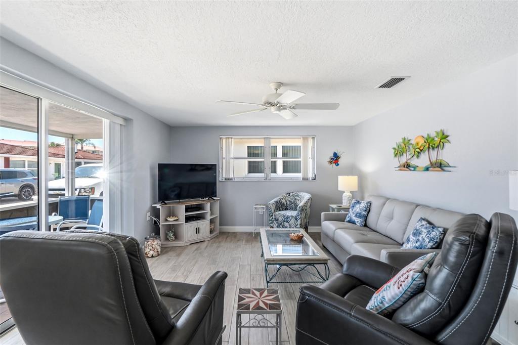 6154 Midnight Pass Road, Unit A05 Sarasota, FL 34242 - Photo 7 of 39 a living room with furniture and a flat screen tv