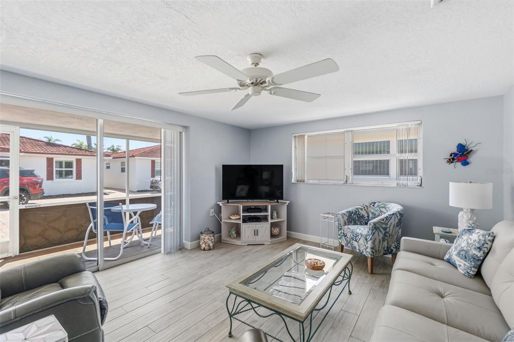 6154 Midnight Pass Road, Unit A05 Sarasota, FL 34242 - Photo 9 of 39 a living room with furniture and a flat screen tv