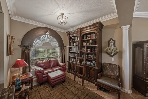 a living room with furniture a ceiling fan and a flat screen tv
