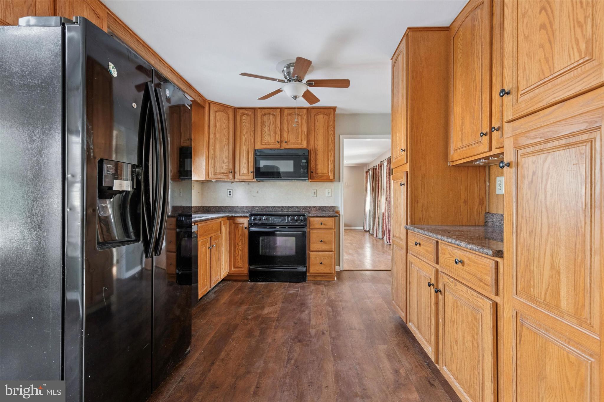 257 Mingo Road Royersford, PA 19468 - Photo 11 of 31 a kitchen with stainless steel appliances granite countertop a refrigerator a stove and a sink with wooden floor