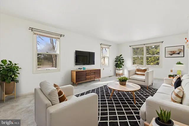 a living room with furniture a window and a flat screen tv