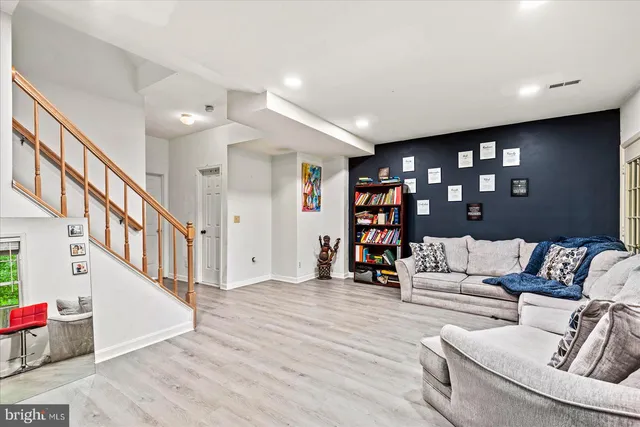 a living room with furniture and a wooden floor