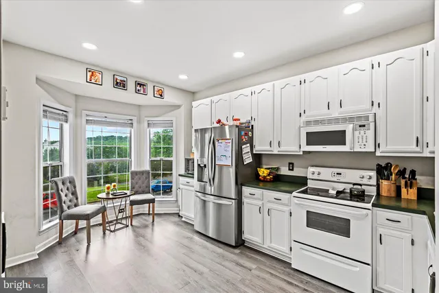 a kitchen with white cabinets and stainless steel appliances