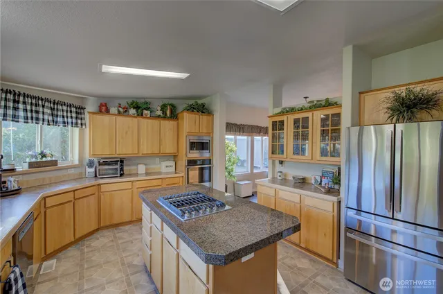 a kitchen with a refrigerator a sink dishwasher stove and oven