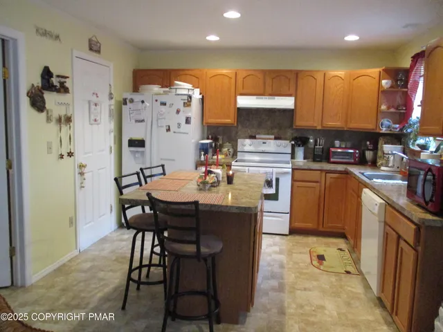 a kitchen with a table chairs refrigerator and microwave