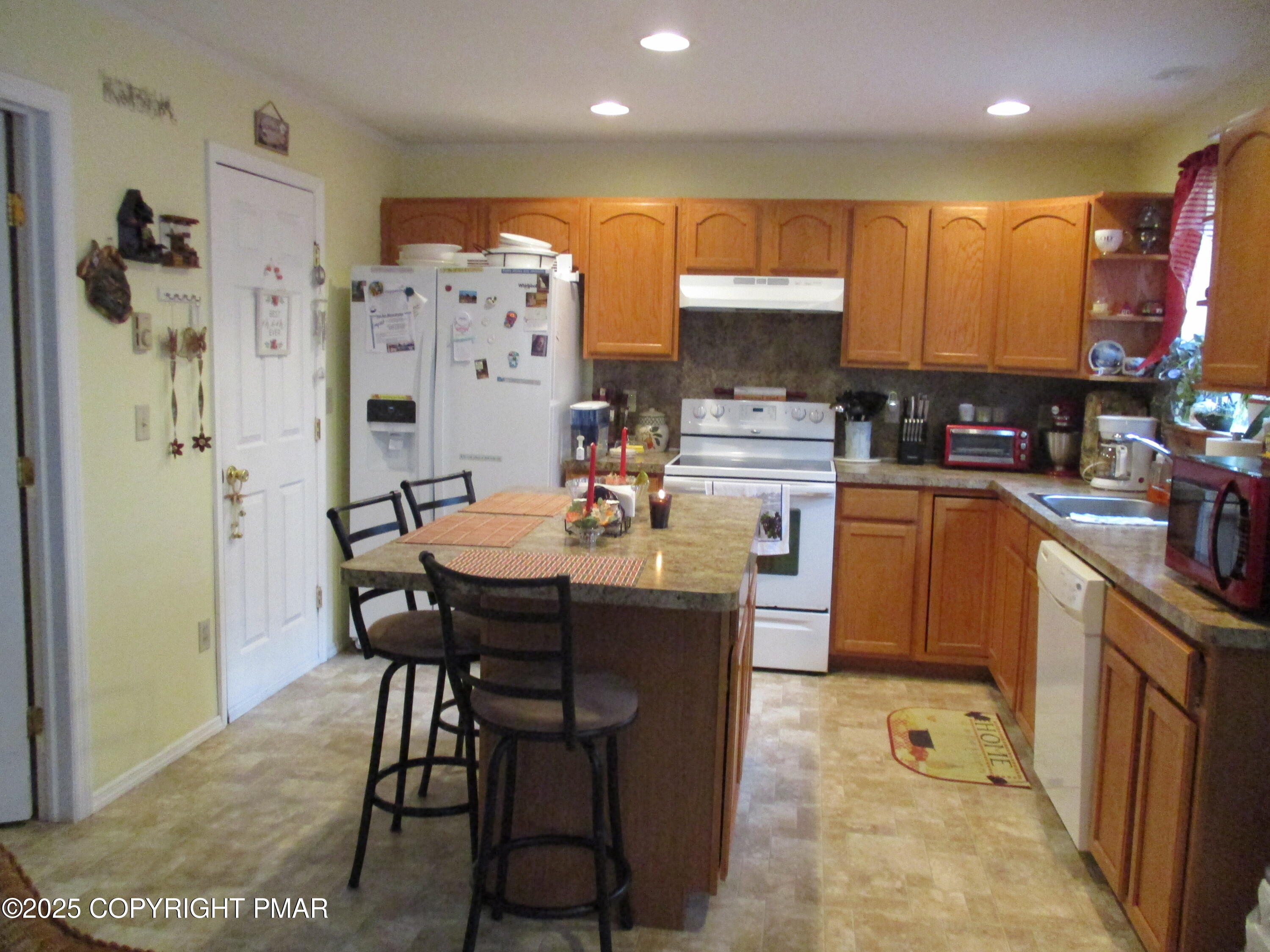 3290 Bluebird Drive Bushkill, PA 18324 - Photo 6 of 19 a kitchen with a table chairs refrigerator and microwave