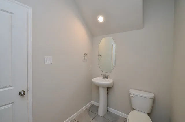 a bathroom with a sink a toilet and a mirror