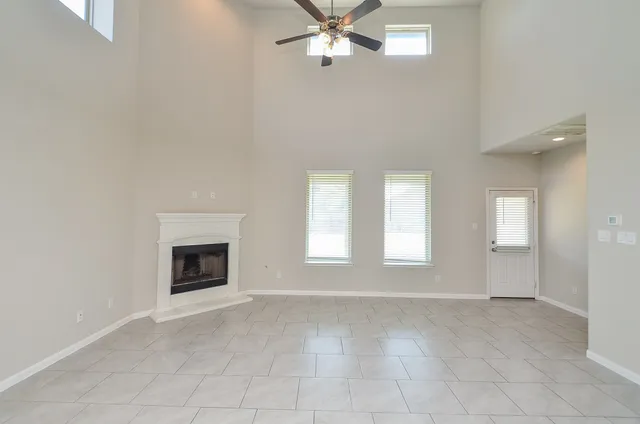 an empty room with windows and fireplace