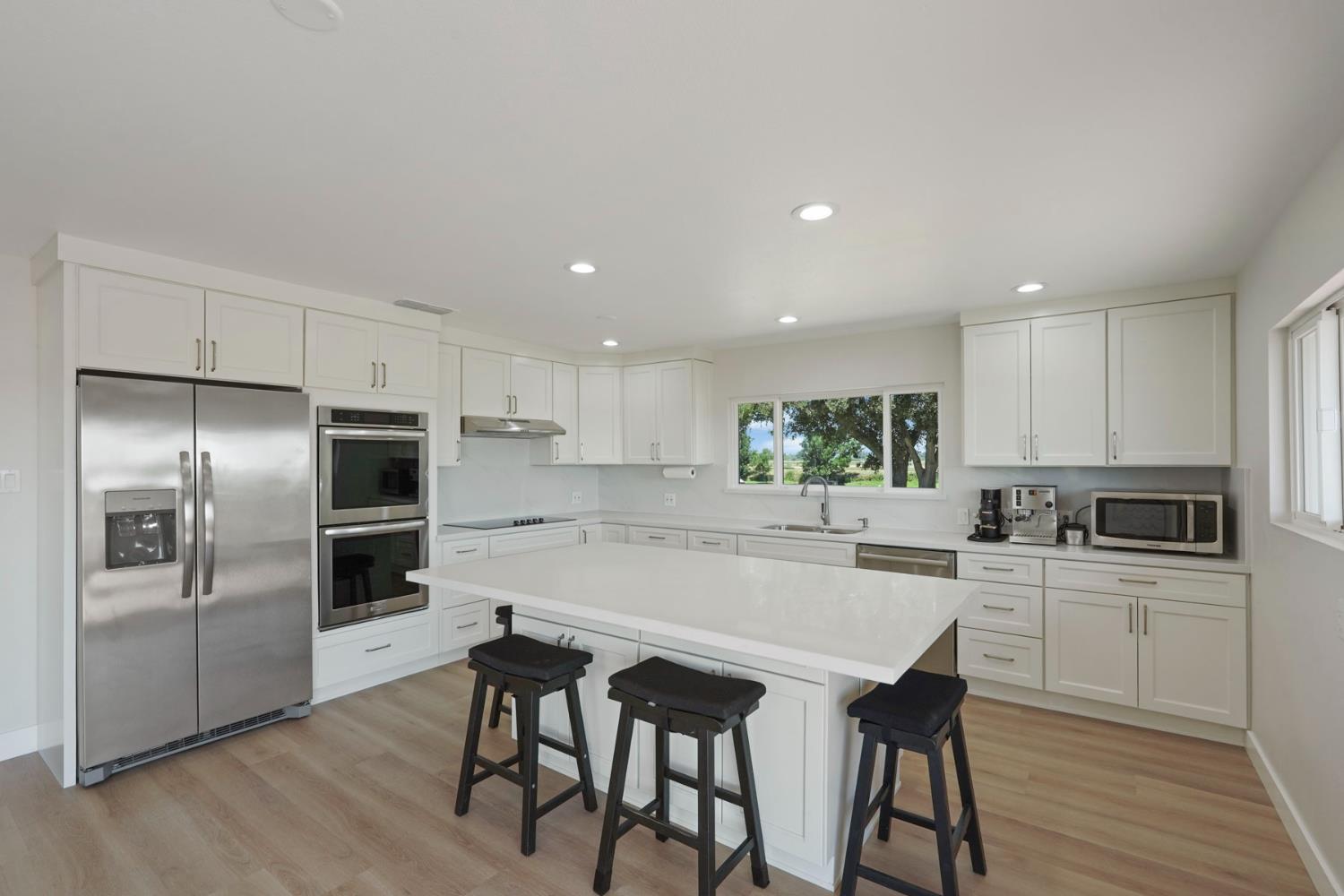 2650 West Twitchell Island Road Rio Vista, CA 94571 - Photo 29 of 60 a kitchen with refrigerator cabinets dining table and chairs