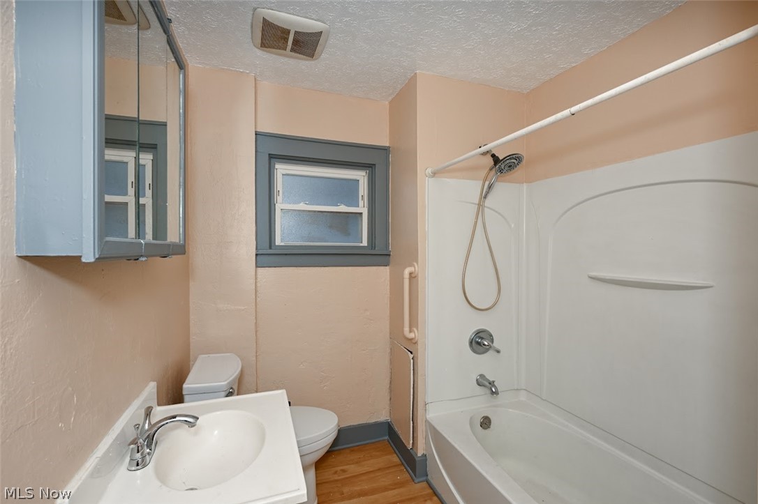 77 West Mildred Avenue Akron, OH 44310 - Photo 36 of 40 Bathroom featuring shower / washtub combination, light wood-style floors, a textured ceiling, and vanity