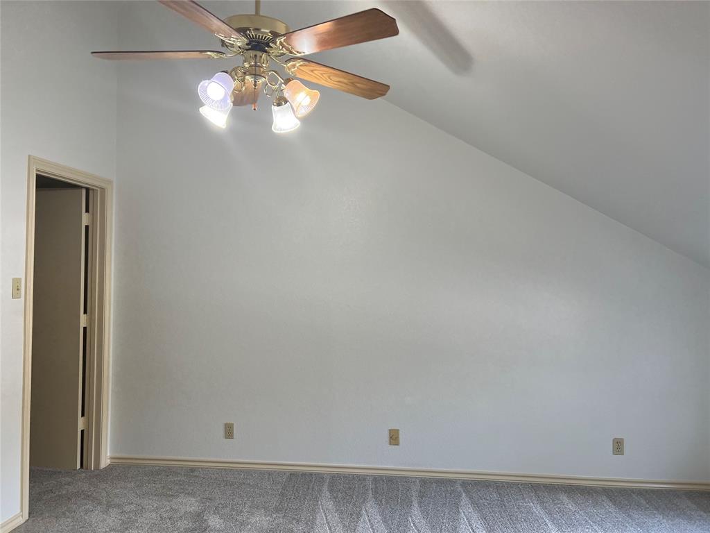1522 Signal Ridge Place, Unit 1522 Rockwall, TX 75032 - Photo 19 of 28 an empty room with a chandelier fan and windows