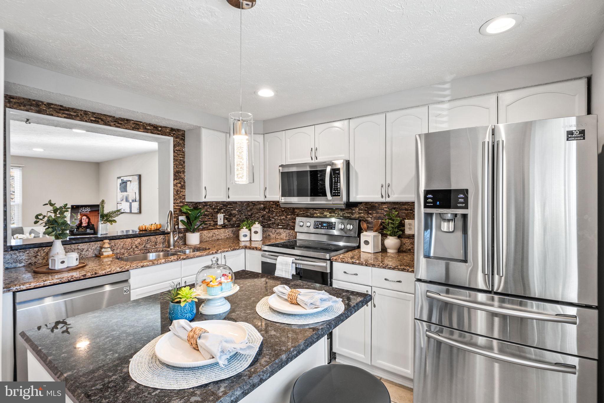 1747 Sundance Drive Reston, VA 20194 - Photo 5 of 36 a kitchen with stainless steel appliances kitchen island granite countertop a dining table and chairs