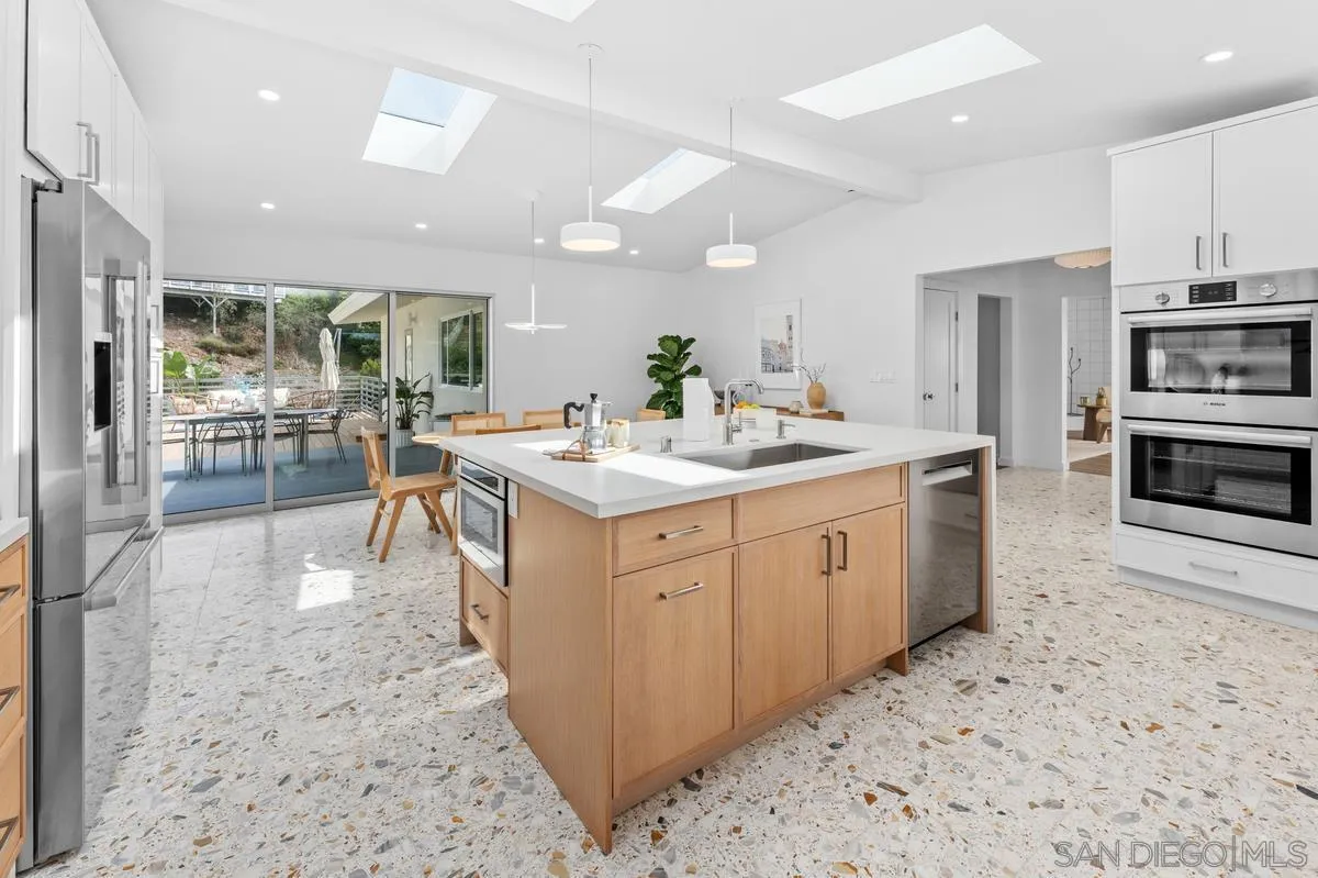 5851 Box Canyon Road La Jolla, CA 92037 - Photo 15 of 39 a kitchen with a sink stove and cabinets