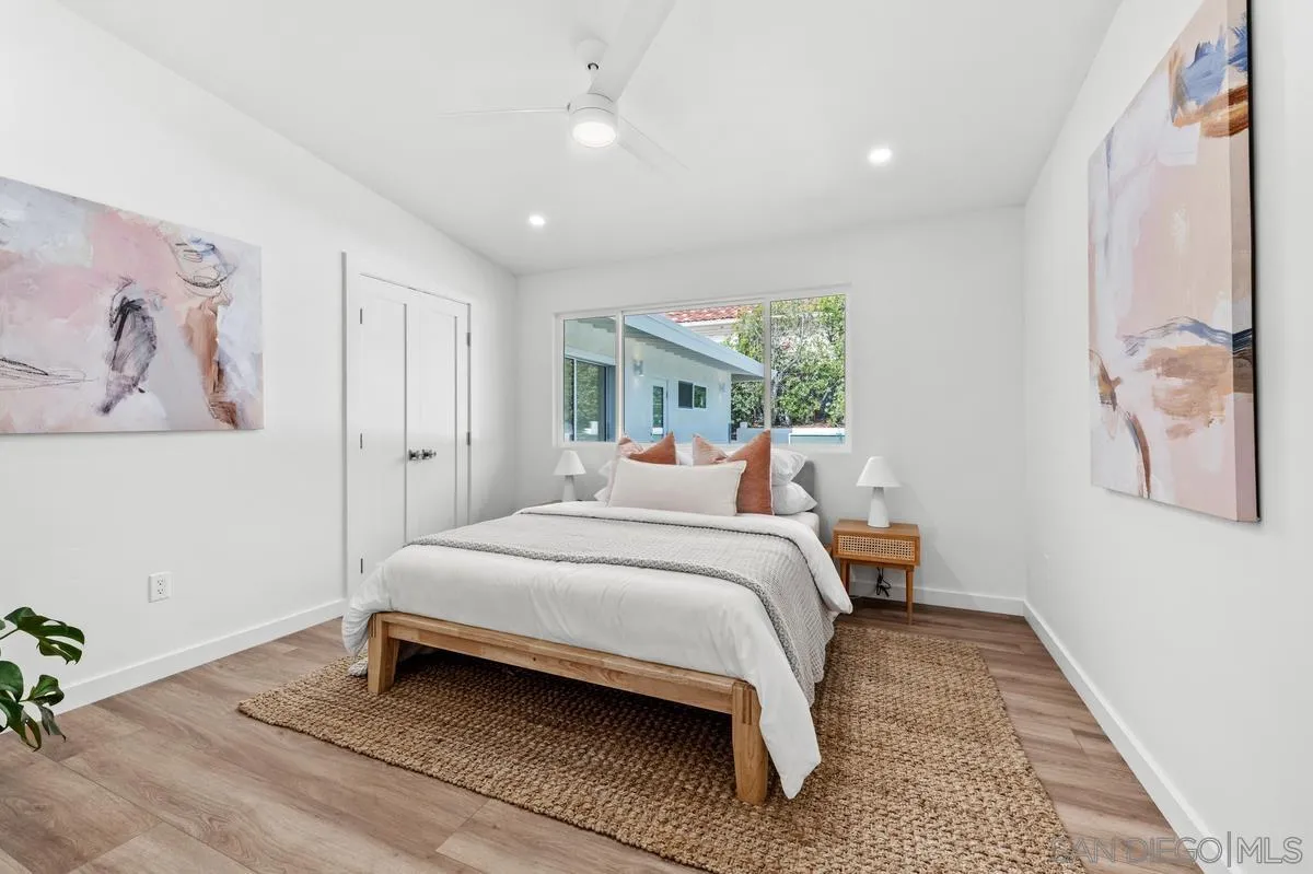 5851 Box Canyon Road La Jolla, CA 92037 - Photo 24 of 39 a bedroom with a large bed and a chandelier