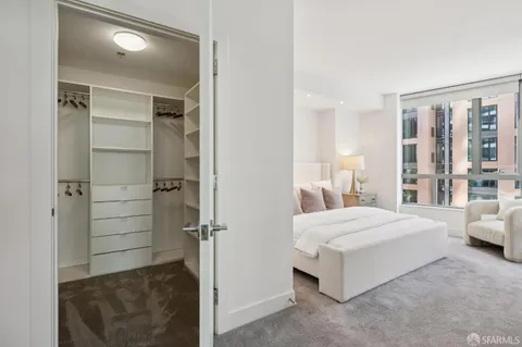 a bedroom with a bed and large windows
