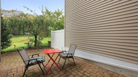a patio with table and chairs and potted plants
