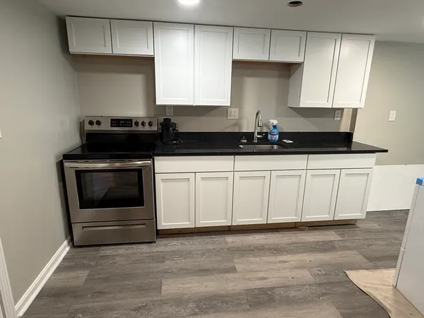 a kitchen with granite countertop white cabinets and stainless steel appliances