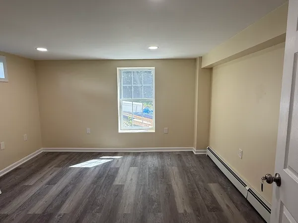 a view of a room with wooden floor and window