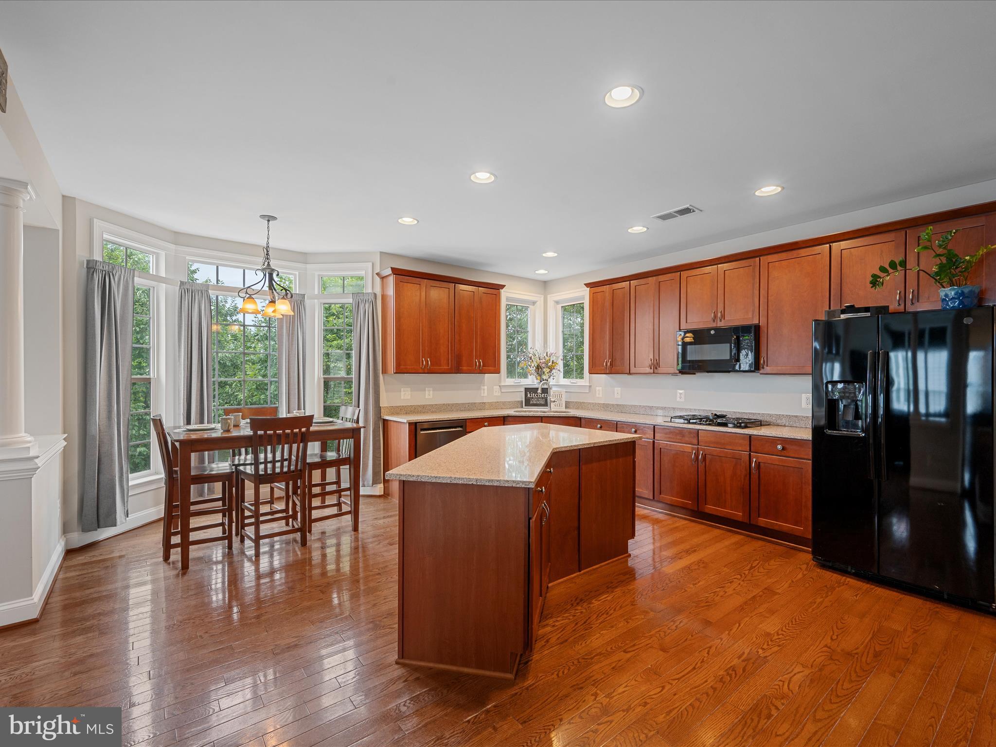 103 Prairie Place Stephenson, VA 22656 - Photo 11 of 90 a kitchen with stainless steel appliances granite countertop a refrigerator a sink a stove and a dining table with wooden cabinet