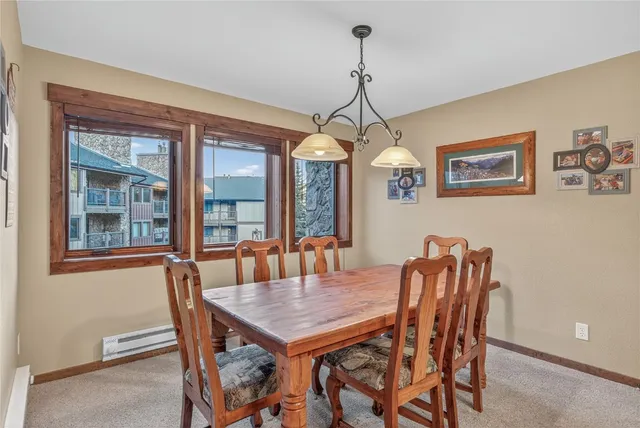 a dining room with furniture a chandelier and window