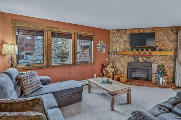 a living room with furniture a flat screen tv and a fireplace