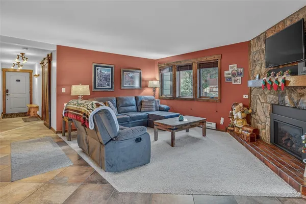 a living room with furniture a flat screen tv and a fireplace