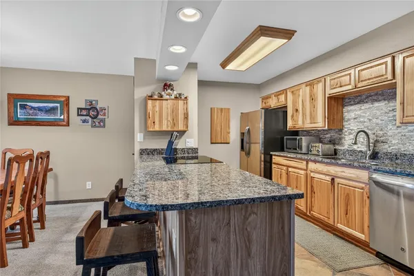 a kitchen with kitchen island granite countertop a sink cabinets and window