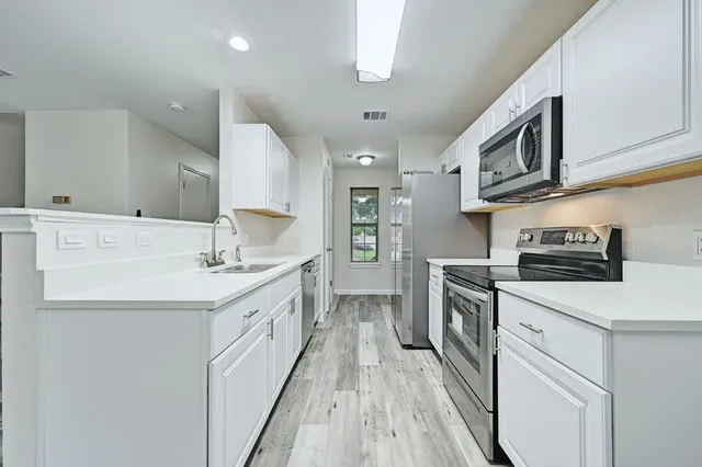a kitchen with stainless steel appliances granite countertop a sink and a stove top oven