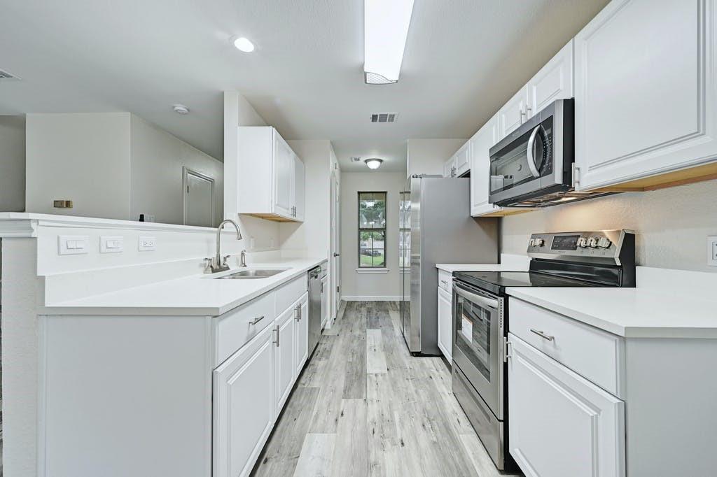 a kitchen with stainless steel appliances granite countertop a sink and a stove top oven