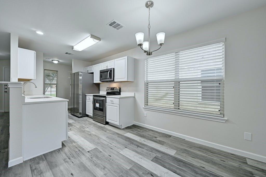 2320 Riddle Road, Unit A Austin, TX 78748 - Photo 2 of 25 a kitchen with stainless steel appliances granite countertop a stove a sink dishwasher a refrigerator and a oven with wooden floor