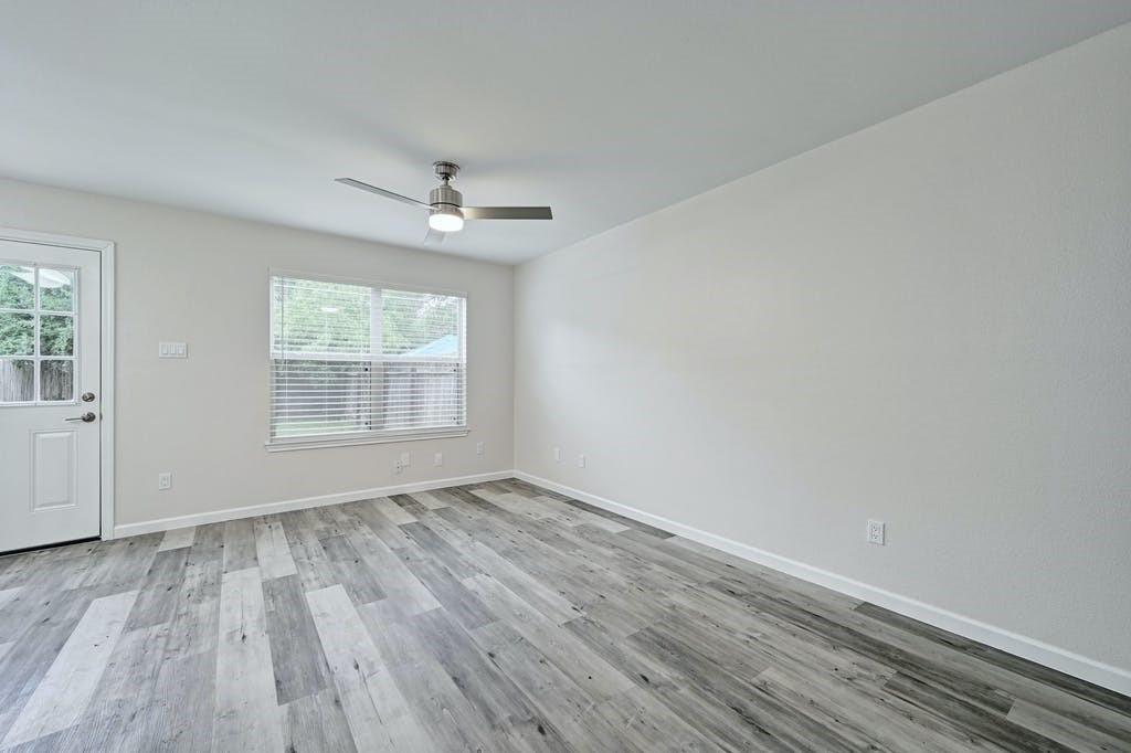 2320 Riddle Road, Unit A Austin, TX 78748 - Photo 7 of 25 an empty room with wooden floor chandelier fan and windows