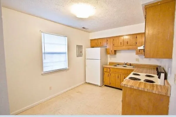 a kitchen with a refrigerator a stove a microwave oven cabinets and a counter top space