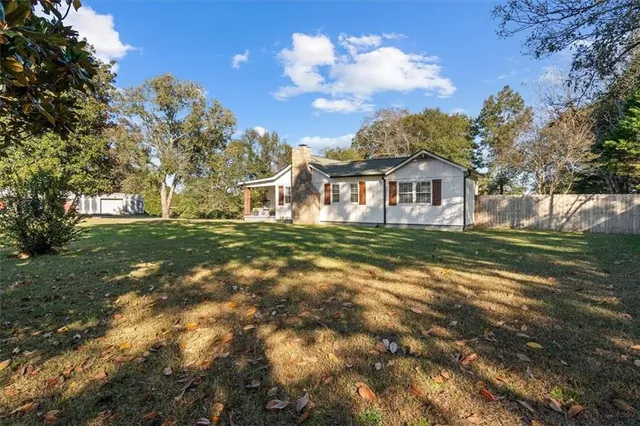 a house view with swimming pool and trees in the background