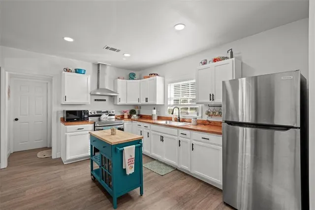 a kitchen with stainless steel appliances granite countertop a sink a stove and cabinets