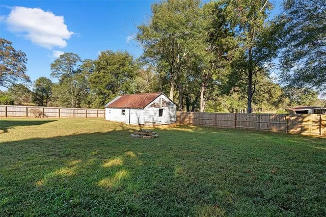 a view of a house with a swimming pool and a yard