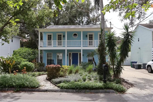 a front view of a house with a yard and palm trees