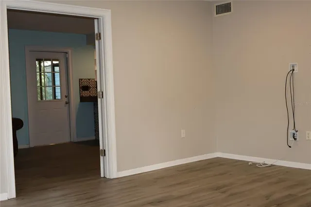 an empty room with wooden floor and closet