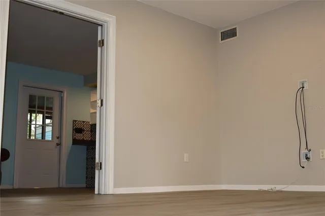 a view of empty room with wooden floor