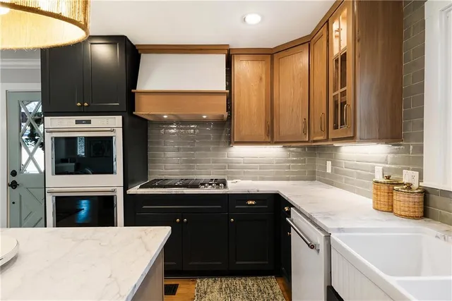 a kitchen with stainless steel appliances a stove microwave and sink