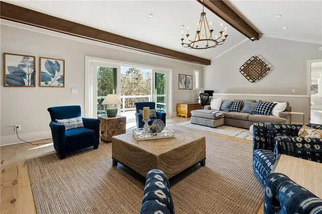 a living room with furniture a large window and a table