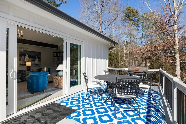 a balcony with wooden floor table and chairs