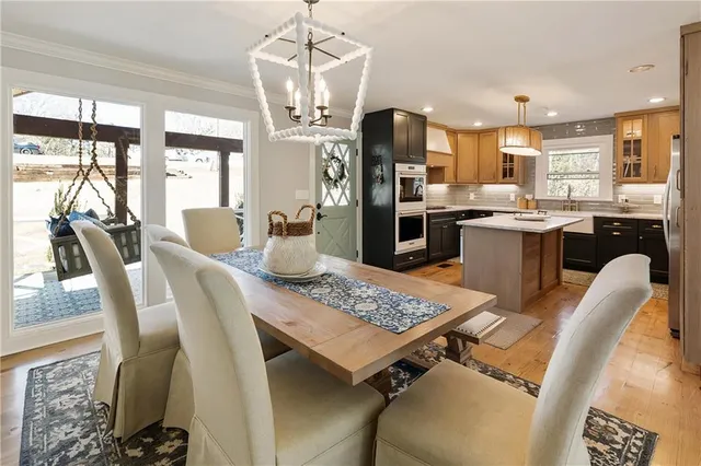 a view of a dining room with furniture a chandelier and wooden floor