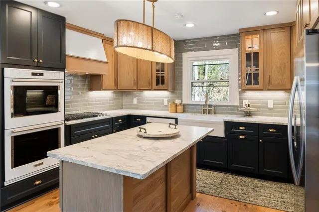 a kitchen with stainless steel appliances granite countertop a sink stove and microwave