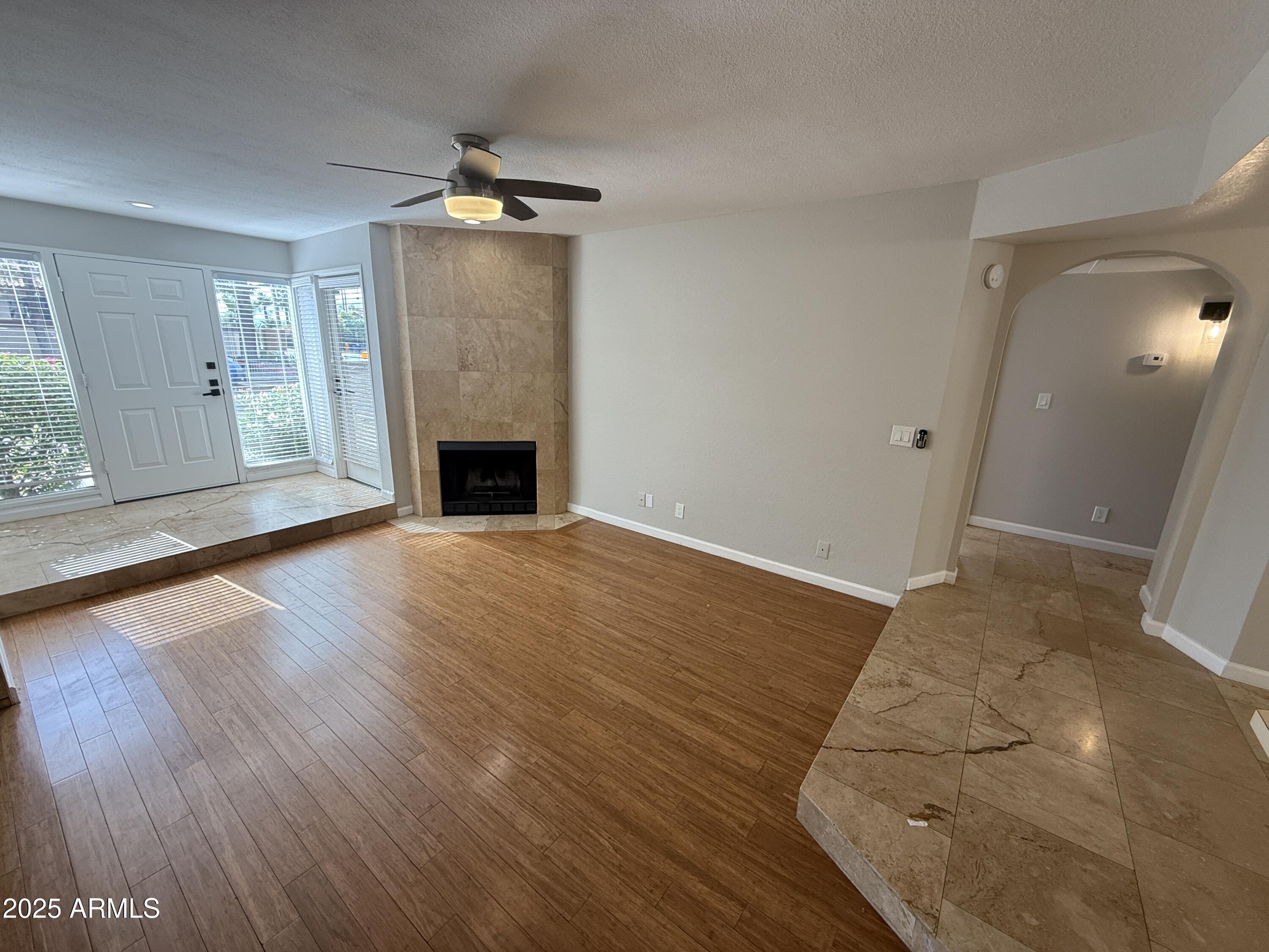 1820 East Morten Avenue, Unit 125 Phoenix, AZ 85020 - Photo 9 of 21 an empty room with wooden floor fireplace and windows