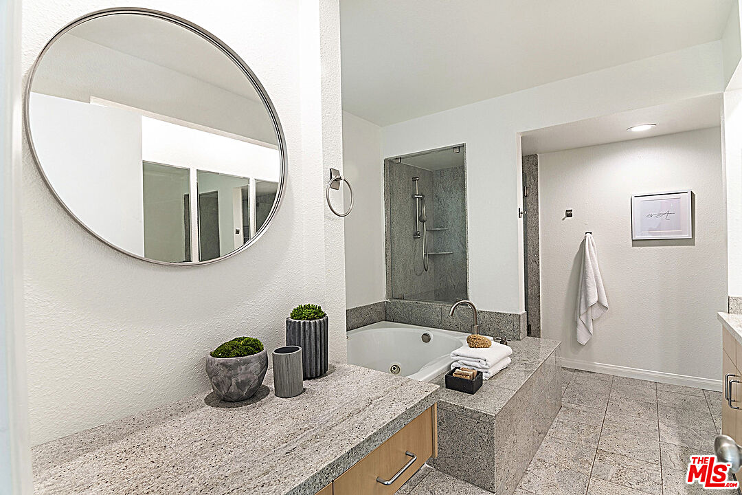 2041 Roscomare Road Los Angeles, CA 90077 - Photo 16 of 28 a bathroom with a granite countertop sink a mirror a vanity and shower