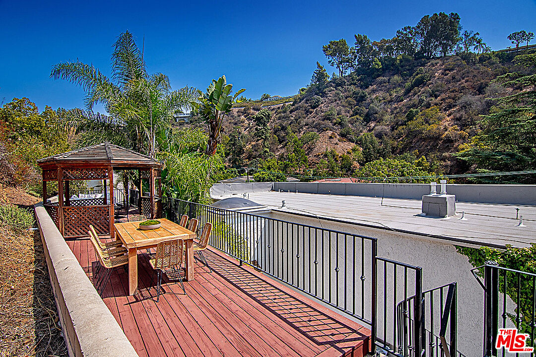 2041 Roscomare Road Los Angeles, CA 90077 - Photo 24 of 28 a balcony with table and chairs